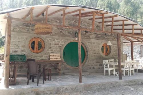 - Vistas al exterior de un edificio con mesa y sillas en Riverside Hobbit House 10mins from Bhimtal, en Bhimtal