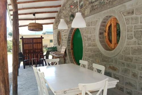 Un comedor con una mesa y sillas blancas. en Riverside Hobbit House 10mins from Bhimtal, en Bhimtal