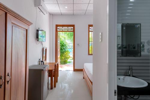Un baño con una cama, un lavabo y una bañera. en Resort Hien Minh Bungalow, en Phu Quoc