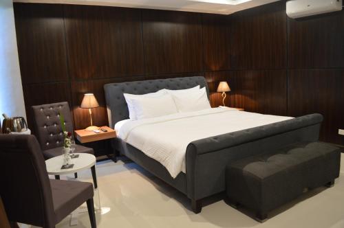 een slaapkamer met een groot bed en een stoel bij Mango Suites - Isabela in Santiago