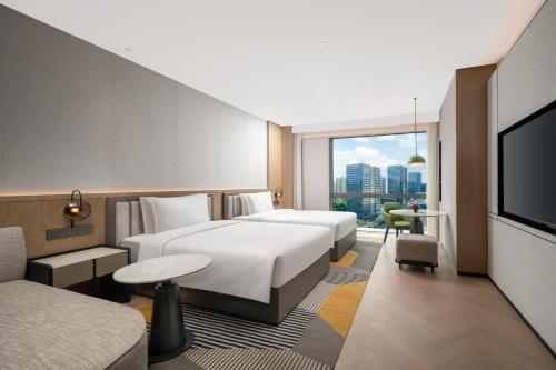 a hotel room with two beds and a flat screen tv at Holiday Inn Kunshan East by IHG in Kunshan