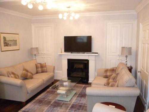 a living room with two couches and a tv at Kings House Wokingham in Wokingham