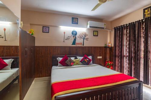 a bedroom with a bed with a red blanket at Sancta Maria in Nedumbassery