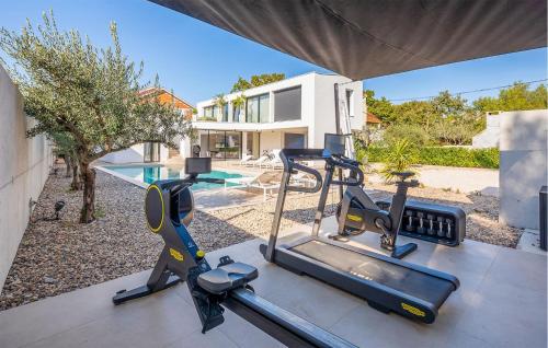 a home gym with two exercise bikes and a house at Villa Amber in Pakoštane
