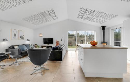 a kitchen and living room with a couch and a table at Awesome Home In Blåvand With Sauna in Blåvand