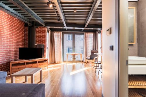 ein Wohnzimmer mit Couch und Fernseher in der Unterkunft Homie Suites - ''Loft 27'' Urban Comfort Suites in the Heart of Cihangir in Istanbul