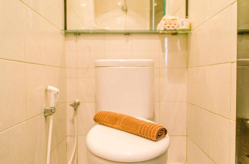 a toilet in a bathroom with a roll at Simple and Cozy Living Studio Room at Poris 88 Apartment By Travelio in Tangerang