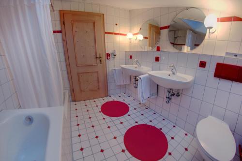 a bathroom with two sinks and a tub and a mirror at Ferienhotel Starennest in Schindelberg
