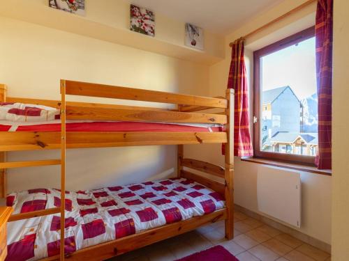 una camera da letto con due letti a castello e una finestra di Chalet cosy 6 pers Peyragudes, navette ski, animaux ok, cheminée, barbecue - FR-1-695-62 a Gouaux-de-Larboust