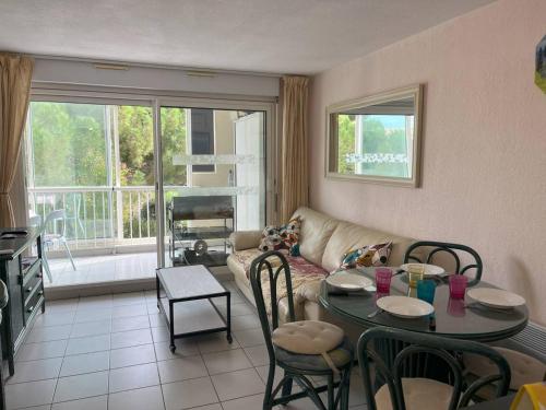 un salon avec une table et un canapé dans l'établissement T2 cabine avec parking et piscine, proche commodités - FR-1-749-73, au Cap d'Agde