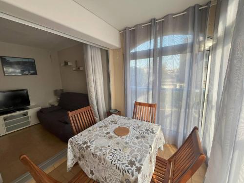 une salle à manger avec une table, des chaises et un canapé dans l'établissement T2 Cabine rénové Cap d'Agde: 4 pers, parking, prox plages - FR-1-749-74, au Cap d'Agde