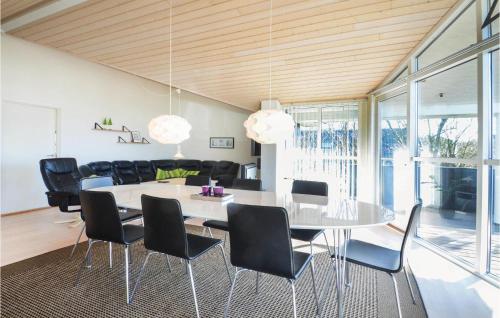 a dining room with a white table and black chairs at Holiday Home Gunhildsvej Vestervig Xi in Vestervig
