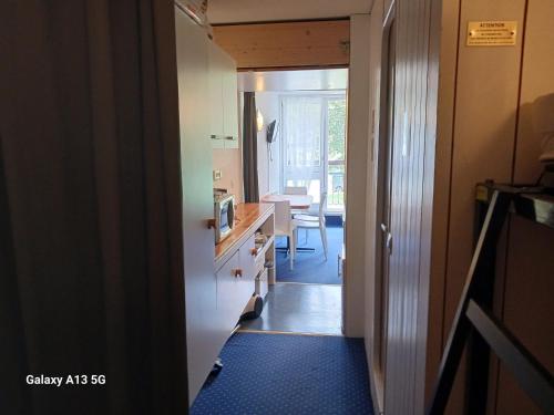 un couloir menant à une cuisine avec salle à manger dans l'établissement Studio skis aux pieds pour 4 pers. à Arc 1800, proche commerces - FR-1-411-952, à Bourg-Saint-Maurice