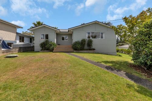 a house with a lawn in front of it at Sea Serenity - Ruakaka Holiday Home in Ruakaka