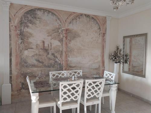 a dining room with a table and chairs and a painting at Kings Apartment with private Garden in Paphos City