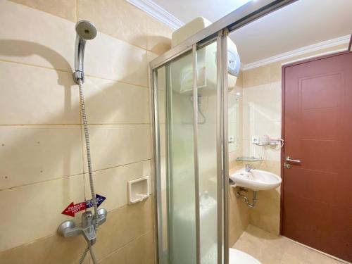 a bathroom with a shower and a sink at Cozy Furnished 3BR at Grand Setiabudi Apartment By Travelio in Bandung