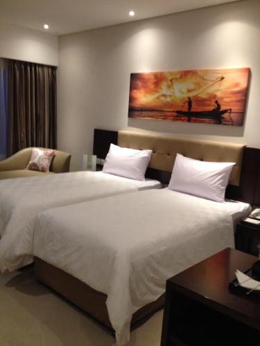 a hotel room with two beds and a painting on the wall at PrimeBiz Tegal in Tegal