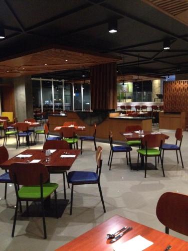 a dining room with tables and chairs and a cafeteria at PrimeBiz Tegal in Tegal