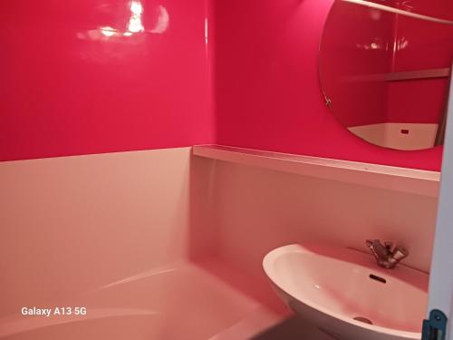 La salle de bains est pourvue de murs rouges, d'un lavabo et d'un miroir. dans l'établissement Studio skis aux pieds pour 4 pers. à Arc 1800, proche commerces - FR-1-411-952, à Bourg-Saint-Maurice