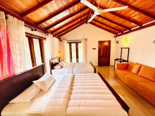 a large room with three beds and a couch at The Blue Sapphire Of Wilpattu in Wilpattu