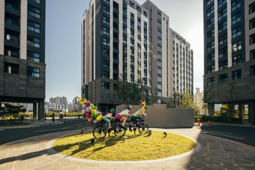 two people riding bikes in a city with balloons at Chestertons Sokcho in Sokcho