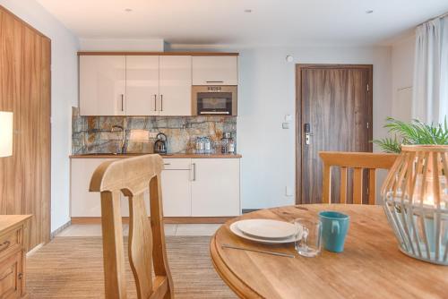 a kitchen and dining room with a wooden table at Hotel Kotarz Spa&Wellness in Brenna