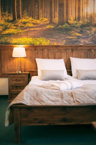 a bedroom with two beds with a painting on the wall at Hotel Kotarz Spa&Wellness in Brenna