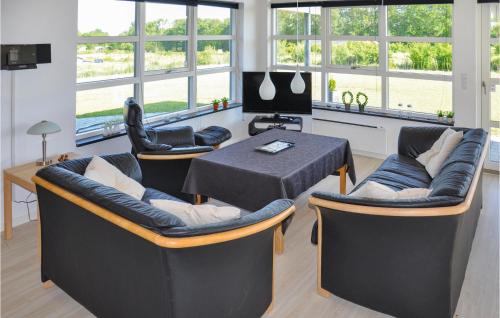 a living room with a table and chairs and windows at Holiday Home Fiskervej Sydals Denm in Skovby