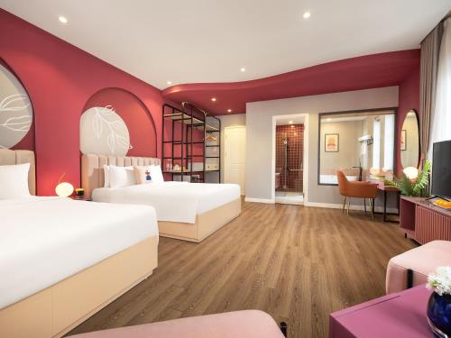 a hotel room with two beds and a tv at Ha Long Essence Boutique Hotel in Ha Long