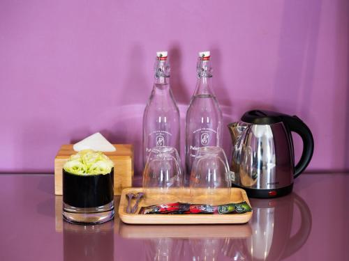 a table with two wine bottles and a coffee maker at Ha Long Essence Boutique Hotel in Ha Long