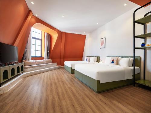 a bedroom with two beds and a flat screen tv at Ha Long Essence Boutique Hotel in Ha Long