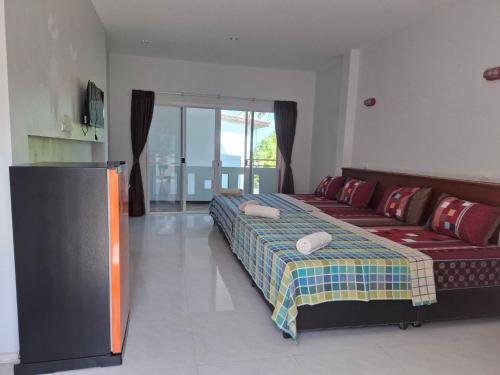 a bedroom with a bed and a couch in a room at Khaolak Summer House 2 in Khao Lak
