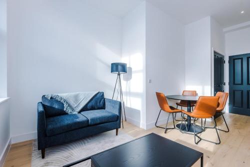 a living room with a blue couch and a table at Stylish 1-Bedroom Getaway in Sale in Sale