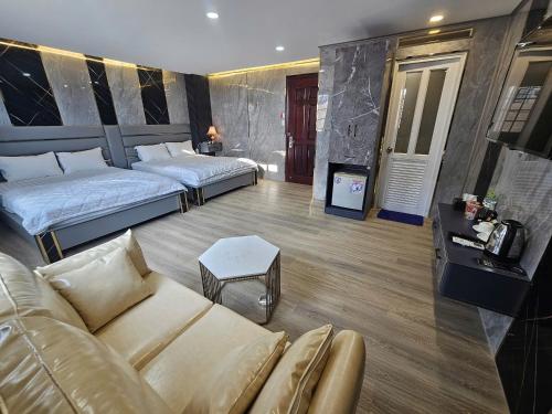 a living room with two beds and a couch at ABC HOTEL BÌNH TÂN in Ho Chi Minh City