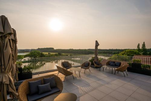 a patio with chairs and couches on a balcony at Jiangnan House Yangcheng Lake Kunshan in Kunshan