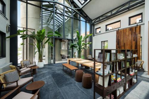 a room with a table and some chairs and books at Jiangnan House Yangcheng Lake Kunshan in Kunshan