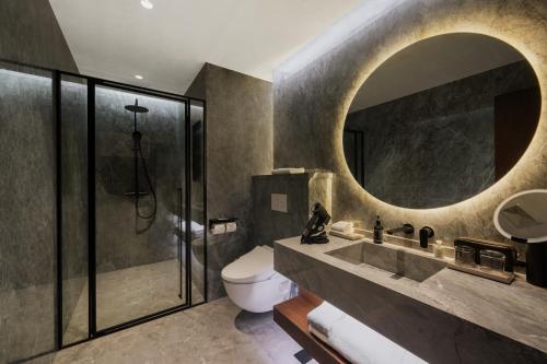a bathroom with a sink and a toilet and a mirror at Jiangnan House Yangcheng Lake Kunshan in Kunshan