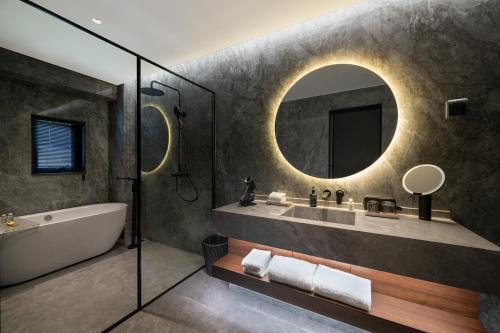 a bathroom with a tub and a sink and a mirror at Jiangnan House Yangcheng Lake Kunshan in Kunshan