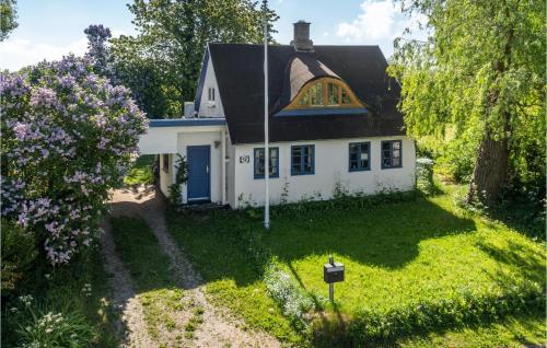 a small white house with a black roof at Awesome Home In Stege With Wifi in Stege