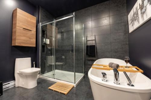 a bathroom with a shower and a tub and a toilet at Saphir, Spacious 2-bedroom apartment, City center, Free parking in Quebec City