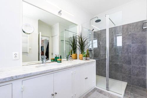 un bagno con due lavandini e una doccia di Estoril Beach Villa a Estoril