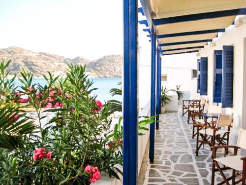 a balcony with tables and chairs and a view of the ocean at Drakos Twins in Mylopotas