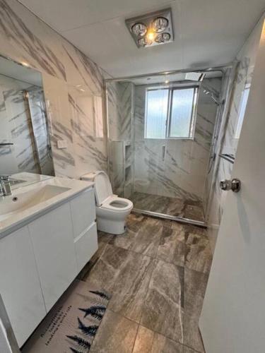 a bathroom with a toilet and a sink and a shower at Alison's central apartment in Cabramatta