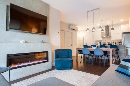 a living room with a fireplace and a table and chairs at Saphir, Spacious 2-bedroom apartment, City center, Free parking in Quebec City