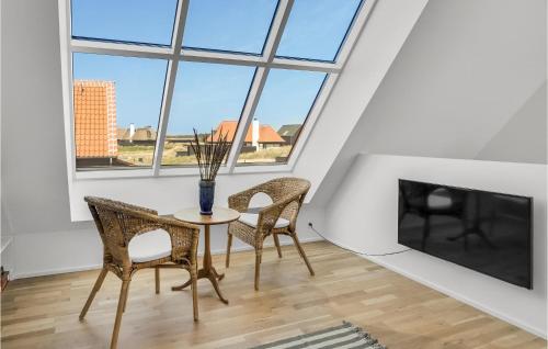 a dining room with a table and chairs and windows at Lovely Home In Skagen With Wifi in Skagen