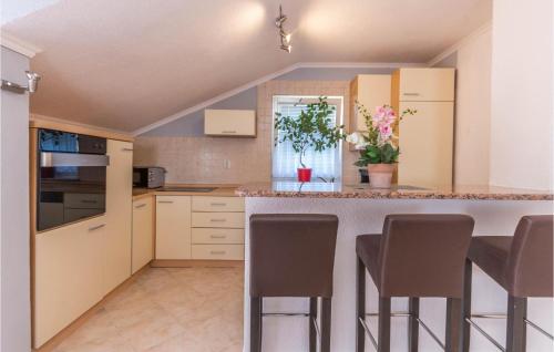 a kitchen with a counter and stools in it at Four-Bedroom Holiday Home In Miranje in Miranje