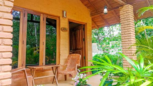 a porch of a house with a table and chairs at Lotus Eco Villa in Sigiriya
