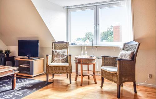 a living room with chairs and a table and a tv at Apartment Blåvandvej Blåvand Iv in Blåvand