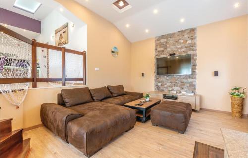 a living room with a brown couch and a tv at Beautiful Home In Hrvace With Wifi in Hrvace