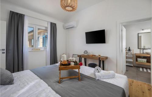 ウグリャンにあるVilla Golden Oliveのベッドと壁にテレビが掛かった寝室